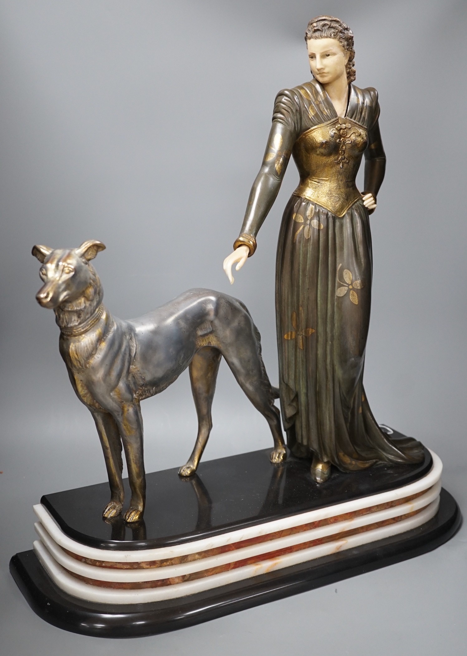 An Art Deco spelter and composition figure of a lady and a hound, signed Menneville, 57 cms high